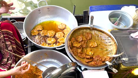 vendor frying mussel pancakes in bangkok market