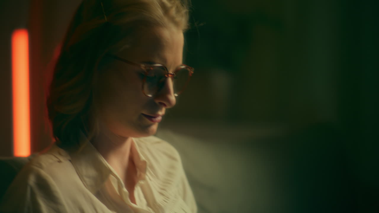 le visage d'une femme travaillant sur un ordinateur portable la nuit