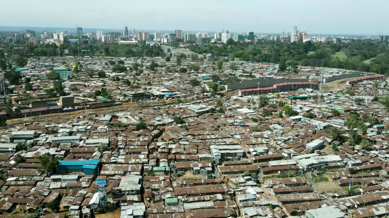 sobrevuelo aéreo pobre kibera slum y moderno horizonte de nairobi en segundo plano durante el día soleado