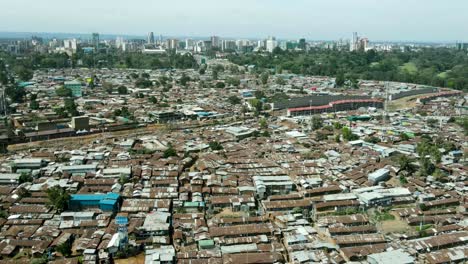 Aerial-flyover-poor-Kibera-Slum-and-modern-skyline-of-Nairobi-in-background-during-sunny-day