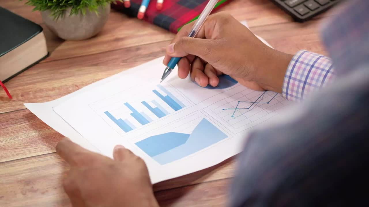 Person gennemgår forretningsdiagrammer og grafer