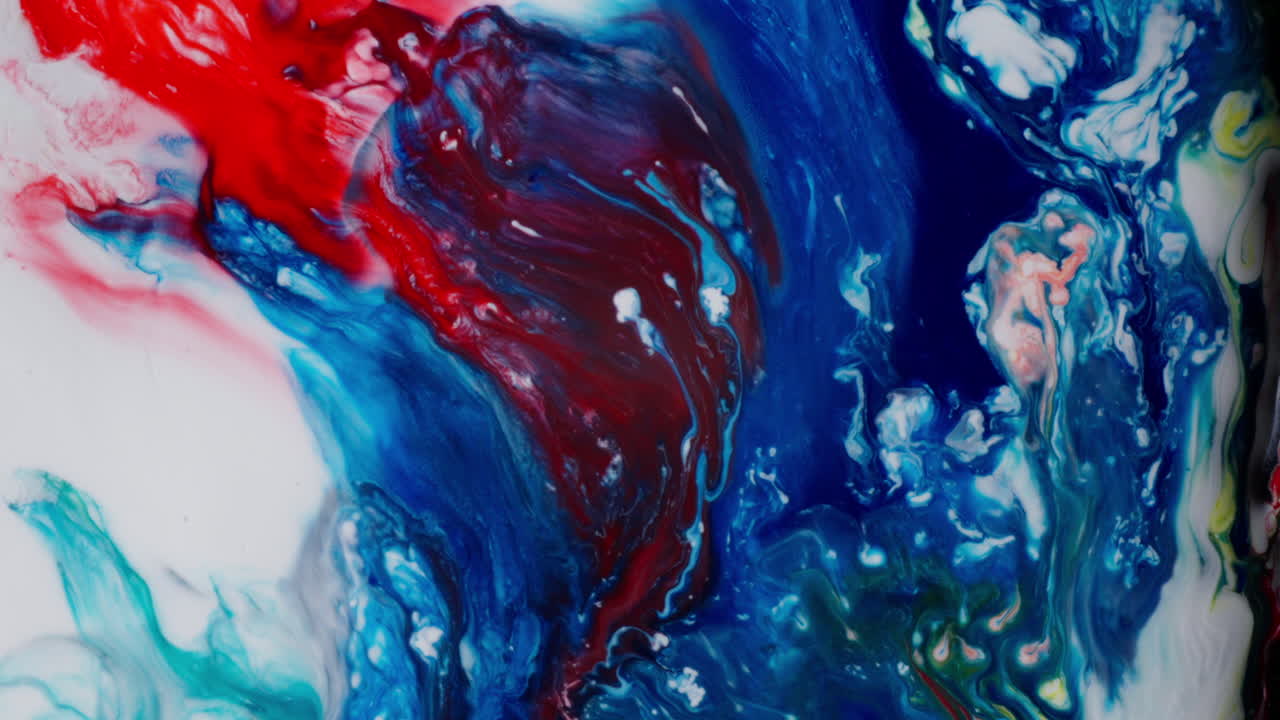 Mezcla macro de tinta colorida que muestra vibrantes remolinos rojos y azules