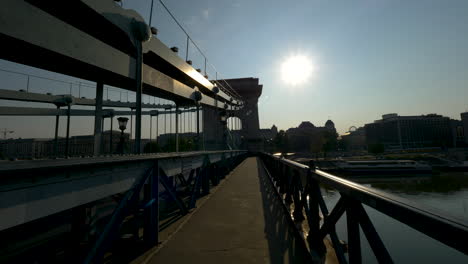 Walking-through-Chain-bridge-at-sunrise,-Budapest,-Hungary