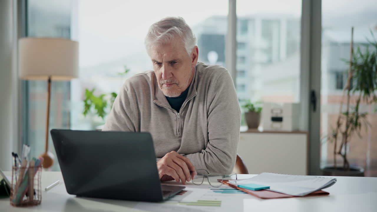 Senior man working on laptop at home office