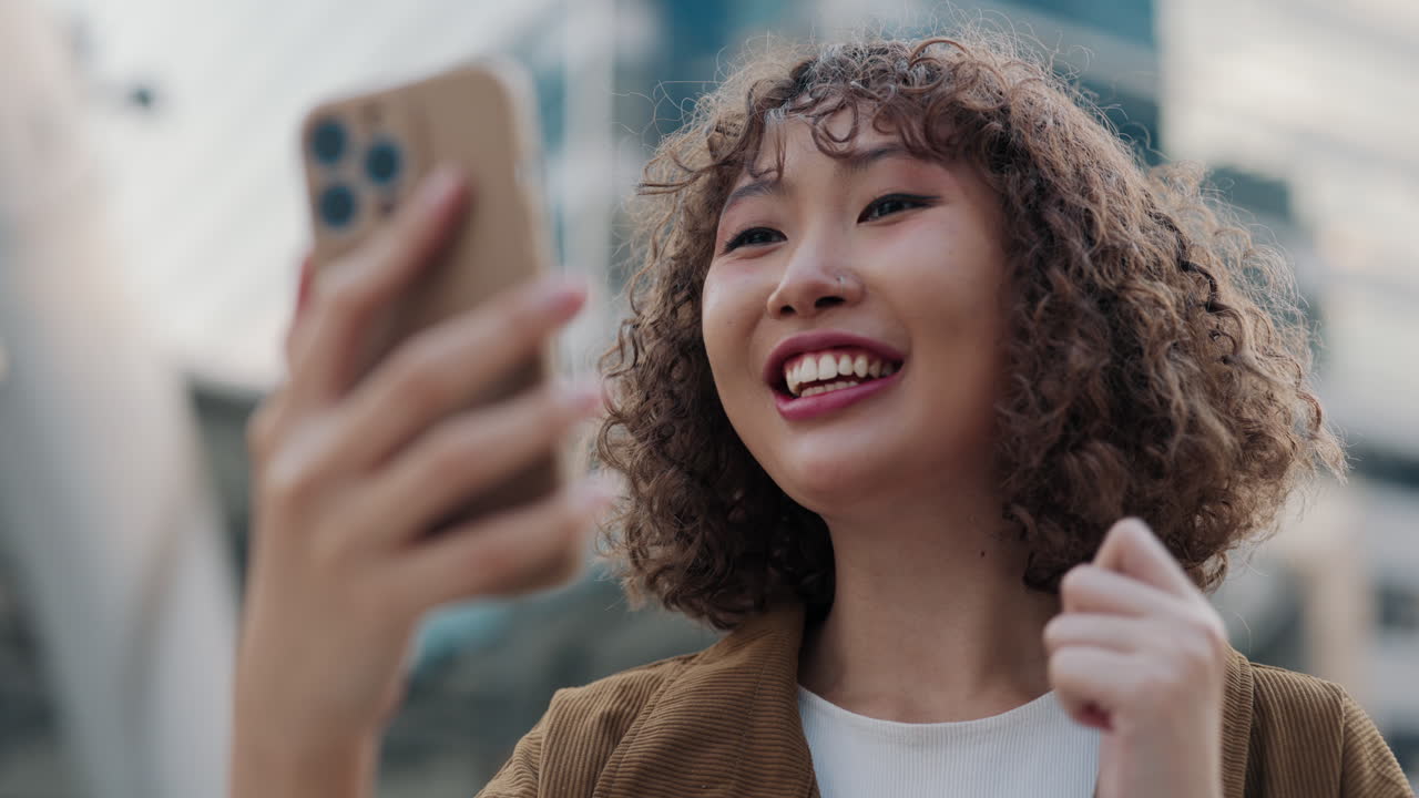 Young Woman Smiling While Using Smartphone