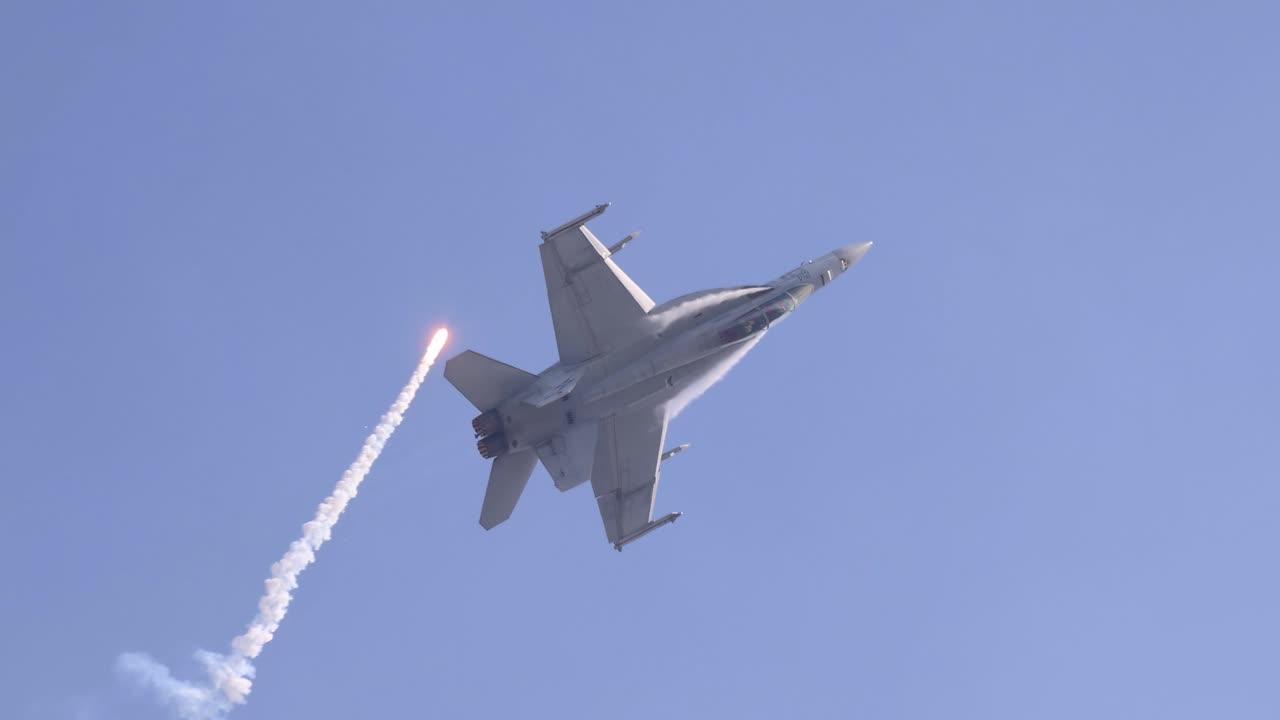 F/A-18 Hornet performs an afterburner climb, releasing flares against a clear blue sky at Avalon Airshow, Geelong