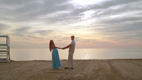 Hombre-Y-Mujer-Tomados-De-La-Mano-En-La-Playa-Del-Mar.-Pareja-Embarazada-Posando-Para-La-Foto