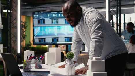 black real estate developer does city planning with architectural sketch