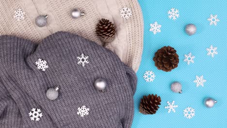 snowflakes, pine cones and knitted sweaters move on blue theme. stop motion