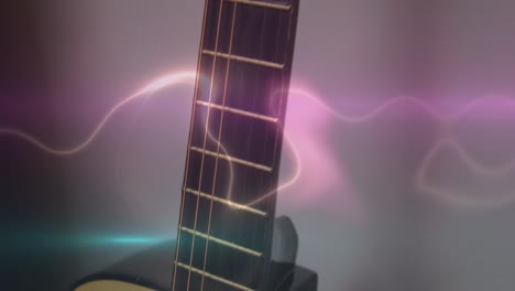 animation of white, blue and pink light trails over acoustic guitar on smokey background