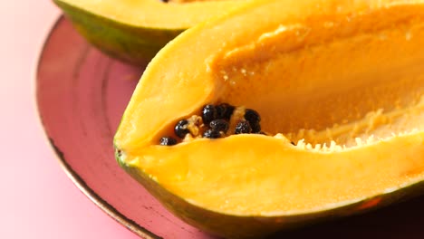 ripe papaya halves on pink plate