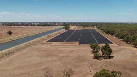 vista aérea de una granja solar junto a un canal de riego en una granja tradicional en australia