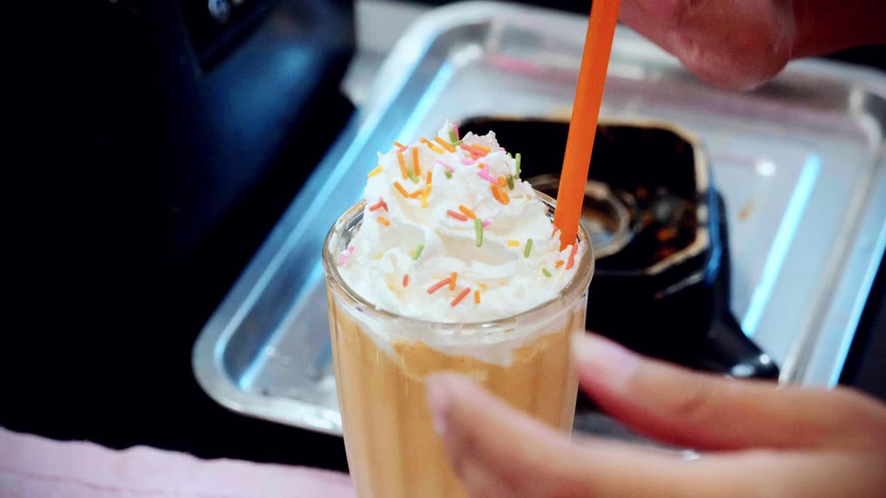 Bir restoran mutfağında, bir barmenin lezzetli ev yapımı milkshake hazırlayıp yaptığı 4K sinematik içecek çekimi, ağır çekimde.