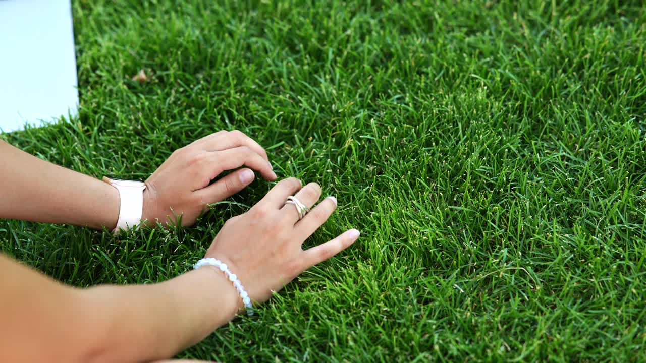 las manos en el césped.