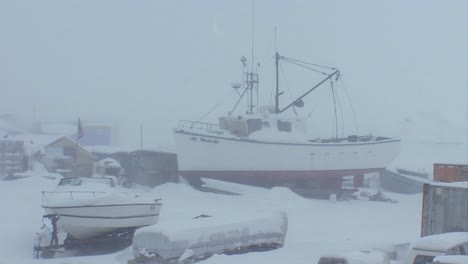 a frozen fishing boat sits in a port in the arctic during winter