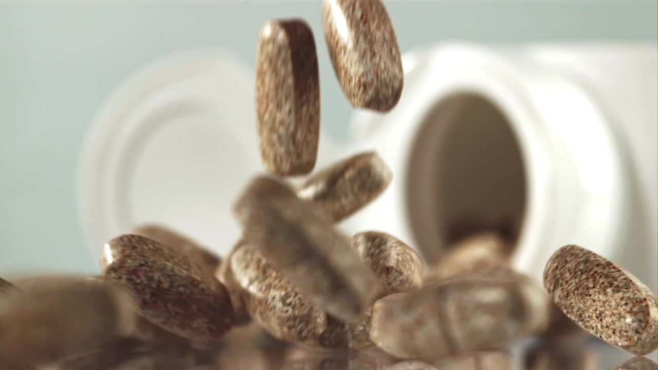 Brown Pills Falling in Slow Motion from a Medicine Bottle