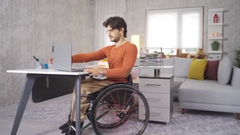 adolescente discapacitado en silla de ruedas trabajando con una computadora portátil.