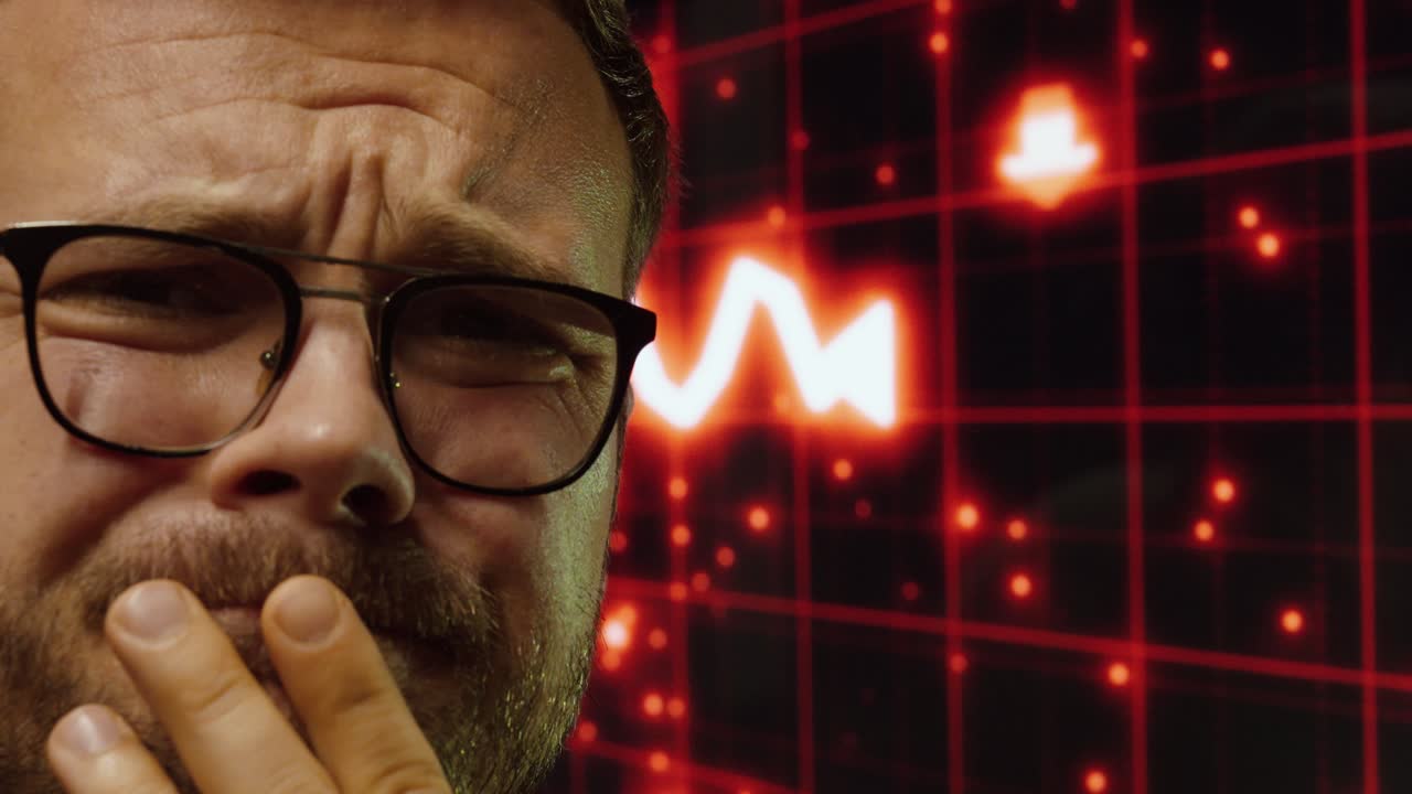 Close-up of a worried man reacting to a market crash shown on a digital screen. Concept of economic crisis, financial loss, and emotional stress in trading