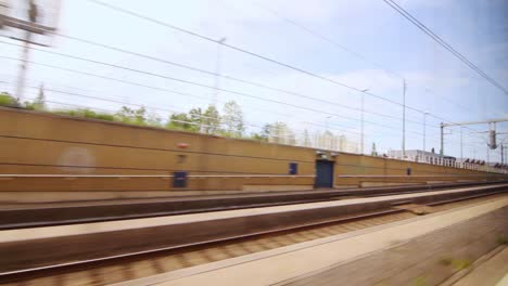 vista desde la ventana del tren en movimiento a lo largo de la plataforma ferroviaria. viaje al país en tren