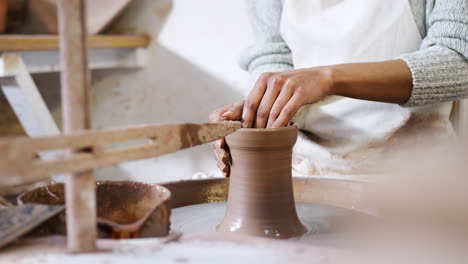 close up of young african american woman working at pottery wheel in ceramics studio