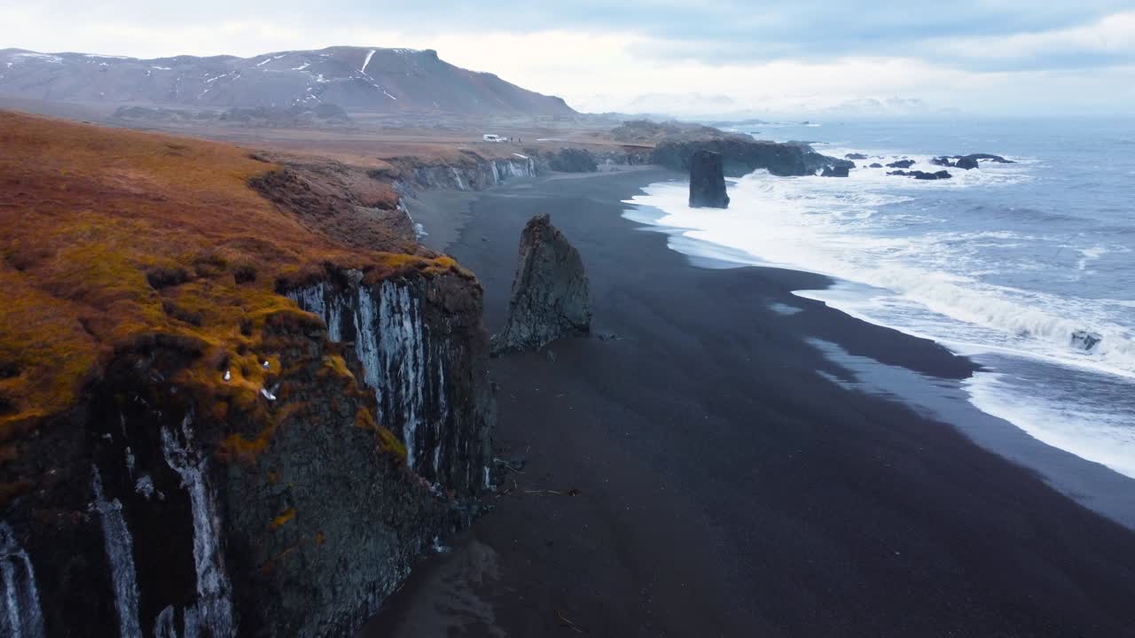 olas del mar en una hermosa playa de arena negra, vista aérea de las olas del océano chocando contra un acantilado de roca de piedra vacía, paisaje volcánico en islandia