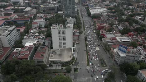 downtown urban aerial tilts to reveal traffic on mexico city street