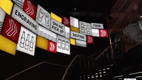 Establishing-pan-of-interior-with-bright-backlit-signs-showing-tasting-and-engraving-at-beer-storehouse