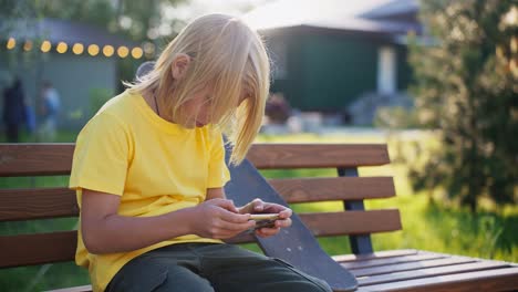 boy sitting on a bench using a smartphone