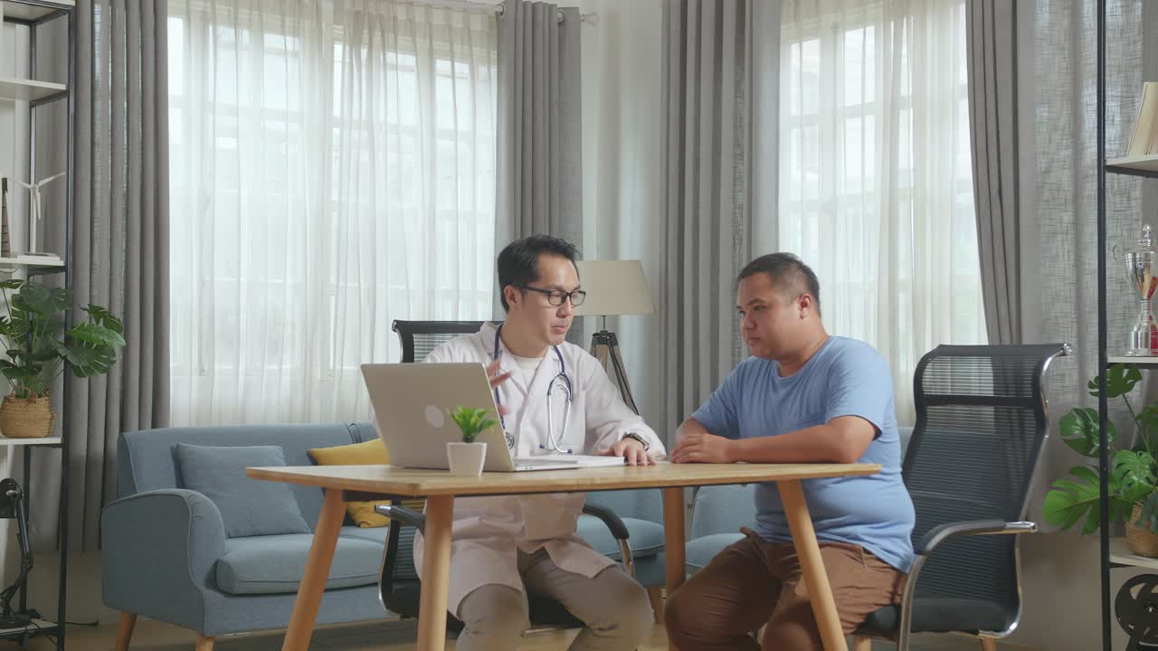 클리닉에서 한 남성 환자와 함께 책상에 앉아 노트북에서 의료 검사 결과에 대해 논의하는 아시아 남성 의사