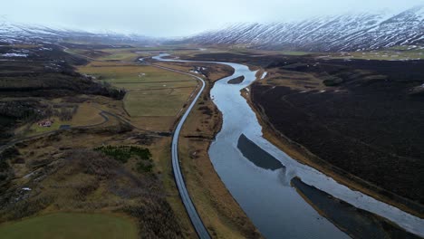 vuelo en torno a un río y una carretera congelados fuera de kirkjufell, islandia