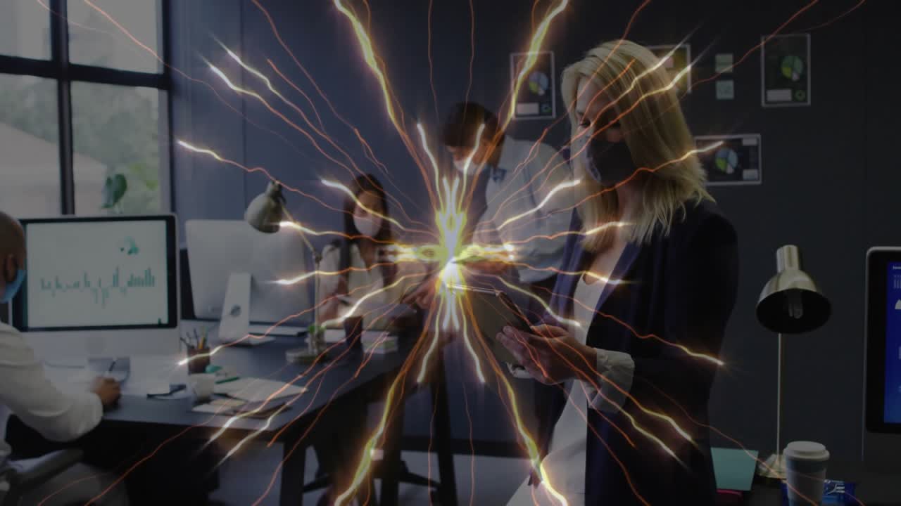 Woman interacting with tablet in office, colleague typing on computer with chart, glowing arcs