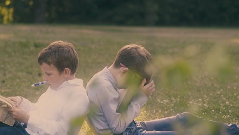 schoolboys in uniform sit on lawn and prepare for exam