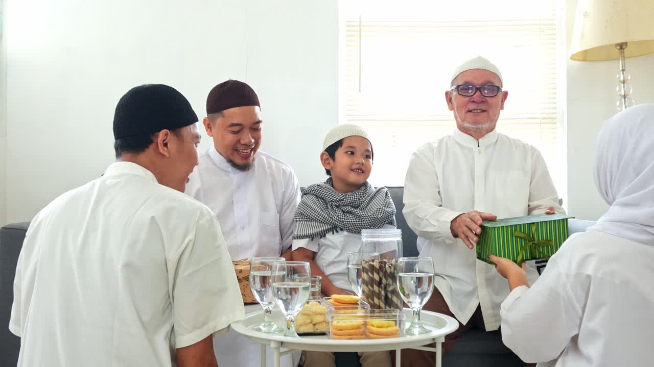 Son And Daughter Giving Gift Box To Father And Grandfather on Celebrating Eid Moment