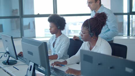 male head of call center operators checking how work is going