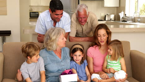 grandmother getting presents from her grandchildren on couch