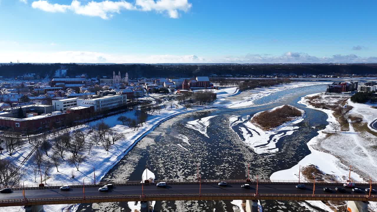 Icy Neris river with bridge and Kaunas downtown, aerial view