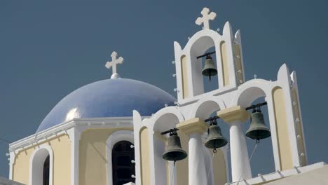 pan of a blue dome and four church bells at fira, santorini