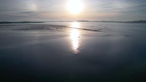 glassy ocean surface with sun reflecting on water