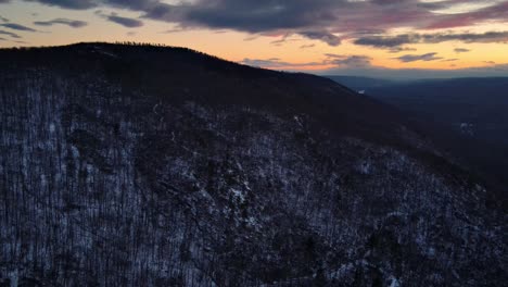 Imágenes-De-Drones-De-Una-Montaña-Boscosa-Cubierta-De-Nieve-Ligera-Durante-El-Invierno-Al-Atardecer-En-Las-Montañas-Apalaches