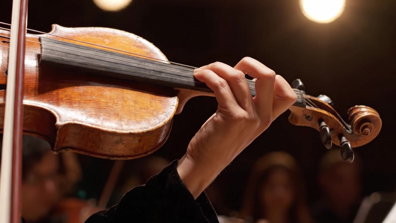 Un primo piano sulla passione musicale: l'arte di suonare il violino illuminata da tecnica esperta ed emozione in una performance incantevole