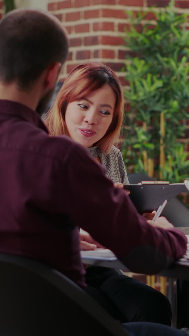 Two colleagues discussing work in an office setting