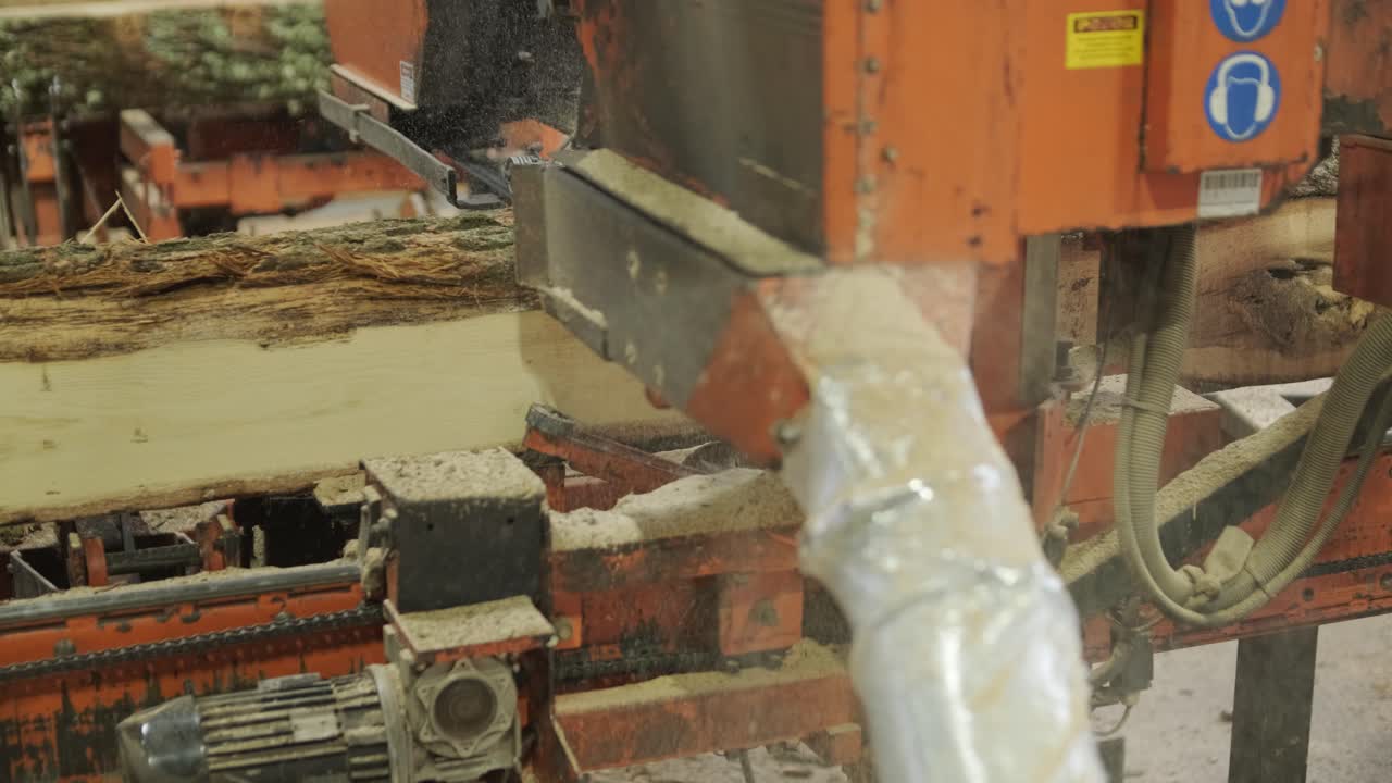 Máquina de Serraria Industrial Cortando um Grande Tronco.