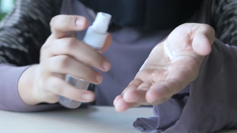 woman using hand sanitizer to disinfect hands