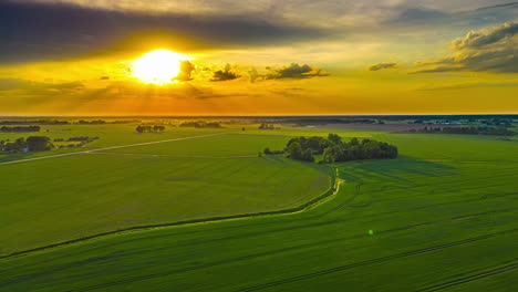 Golden-sunset-aerial-hyper-lapse-over-a-lush,-green,-farmland-countryside