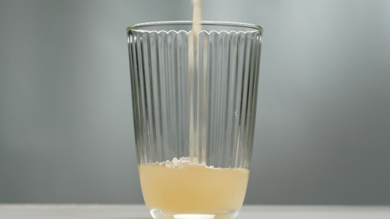 Orange or white wine bottle and glass, spanish french apple cider pouring, pouring of ecological natural wine.