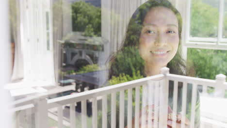 portrait of happy asian woman looking through window, in slow motion