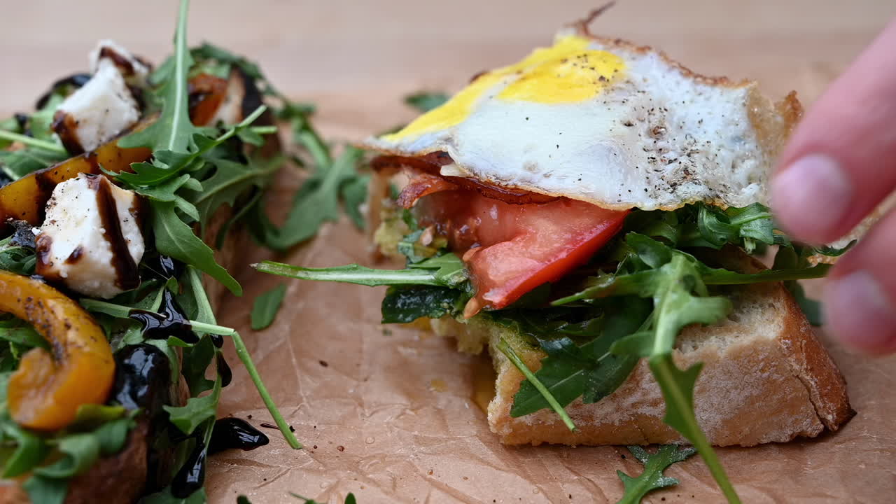 Close up of a man eating bruschetta with different types of toppings