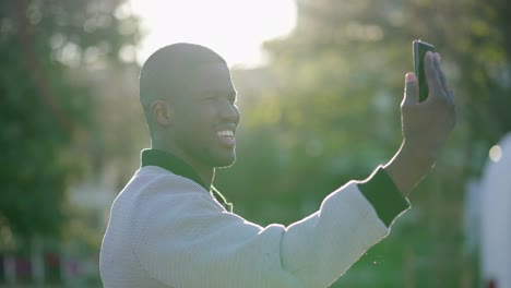 Man-having-video-chat-on-phone-in-park,-showing-surroundings