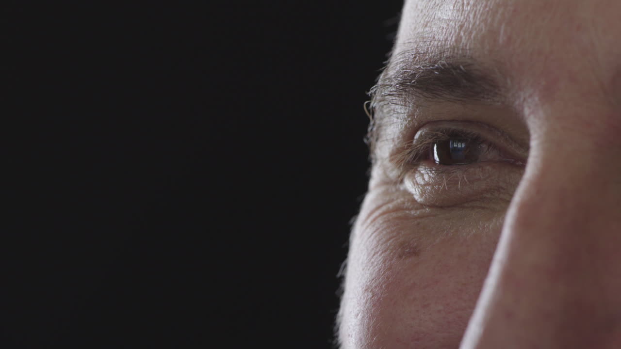 cerca del ojo masculino mirando sonriendo feliz en el fondo negro espacio de copia