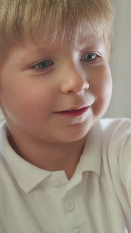 hermano y hermana se sientan en el escritorio con la computadora portátil. niña en edad preescolar y niño pequeño sonríen viendo videos divertidos. niño señala el dedo a la pantalla comentando expresivamente en primer plano